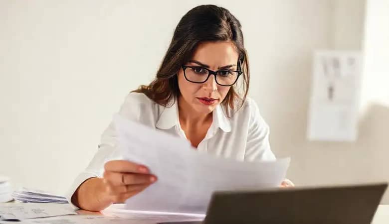 Mujer inteligente revisa documentos con seriedad